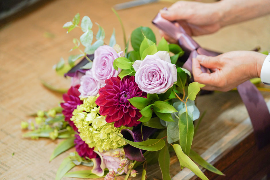 花束にリボンを結んでいるところ
